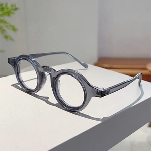 Vue détaillée des lunettes rondes rétro gris transparent sur un support blanc