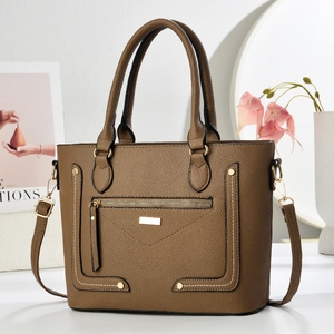 Detail of brown lychee grain leather handbag with gold hardware and fine stitching