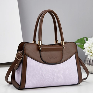 Detail view of contrast color handbag with python texture and golden fashion hardware