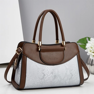Detail of color-block pillow bag with brown leather, snake pattern and gold hardware