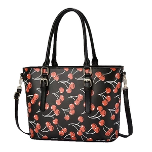 Black tote bag featuring red cherry prints and golden hardware with a detachable shoulder strap