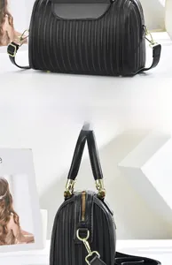 Dettaglio della borsa Boston nera con trama a pieghe verticali e metalleria color oro