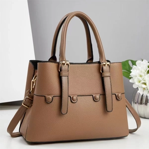 Detail of dark khaki lychee leather handbag featuring gold buckles and wavy stitching