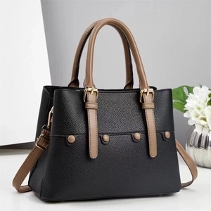 Large black pebbled leather tote bag with brown handles and elegant gold hardware
