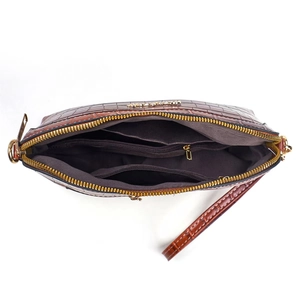 Internal view of dark brown crocodile-patterned crossbody bag with three compartments