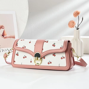 Sac bandoulière élégant à motif cerise avec bordure rose et fermoir doré sur fond épuré