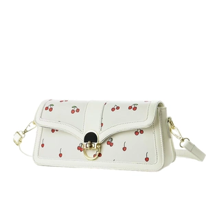 Sac à bandoulière blanc crème avec motif cerise rouge et fermoir doré sur fond uni