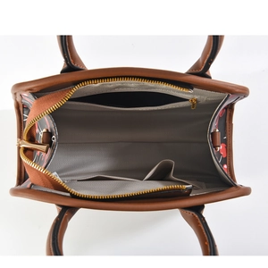 Detail view of brown tote bag interior with cherry print and grey herringbone lining