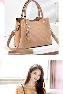Détail du sac à main beige texturé avec pendentif perle feuille et ferrures dorées