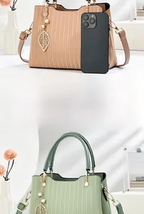 Détail de sacs plissés en beige et vert avec breloques feuilles et téléphone pour l'échelle