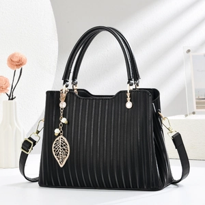 Sac à main noir plissé avec pendentif perle feuille d'or sur socle en pierre minimaliste