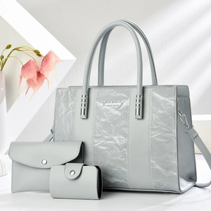 Three-piece light grey tote bag set with pleated texture and silver logo on white background
