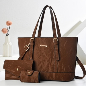 Three-piece brown leather handbag set including a tote, clutch, and round coin purse