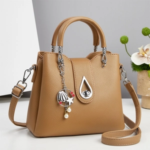 Elegant tan faux leather bucket bag with seashell pendant and metallic water-drop clasp