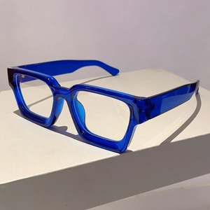 Close-up of thick square blue transparent eyeglass frame on a white display pedestal