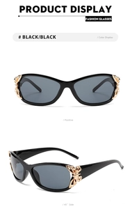 Detail of black fashion sunglasses featuring a gold butterfly metal hinge ornament