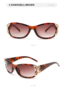 Detail of tortoiseshell sunglasses with golden butterfly accents and brown gradient lenses