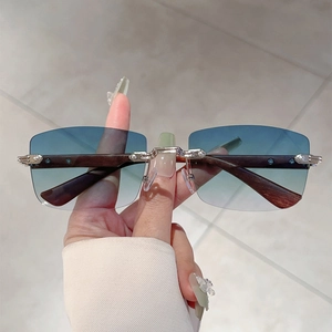 Close-up of rimless sunglasses featuring blue gradient lenses and textured wood temples