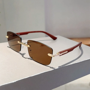 Close-up of rimless brown rectangle sunglasses with gold metal bridge and wood texture arms