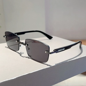 Detailed close-up of dark grey rimless square sunglasses with gunmetal finish hardware