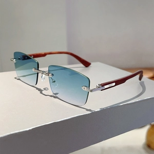 Detail of rimless rectangle sunglasses with blue gradient lenses and wood grain temples