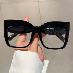 Détail des lunettes carrées surdimensionnées noires montrant la charnière et le marquage CE