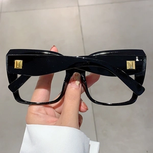 Vue détaillée de montures de lunettes noires épaisses avec rivets dorés polis
