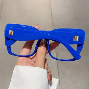 Détail des lunettes carrées surdimensionnées bleu électrique avec rivets carrés dorés