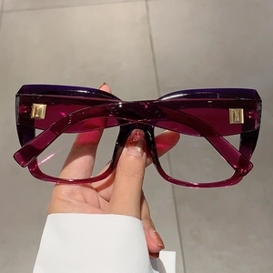Détail des lunettes carrées violettes translucides avec rivets métalliques dorés