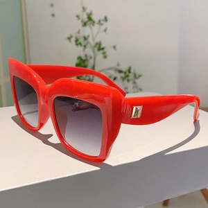 Vue détaillée des lunettes de soleil rouges oversize avec verres dégradés et dorés
