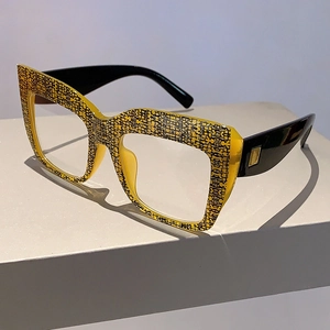 Détail de lunettes carrées œil-de-chat avec motif résille jaune et branches noires