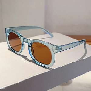 Macro detail of transparent light blue round sunglasses frame with silver metal rivets