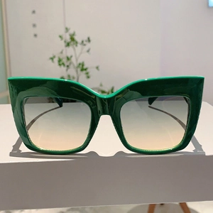 Détail de lunettes de soleil œil de chat vert surdimensionnées avec verres dégradés