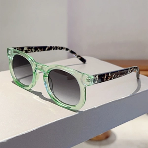 Close-up of light green round sunglasses with tortoiseshell temples and gradient lenses