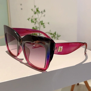 Détail de lunettes de soleil à verres dégradés avec des accents dorés sur les branches