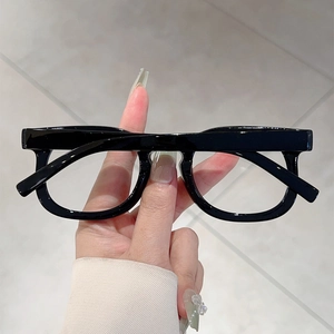 Detail of vintage thick black acetate eyeglass frames shown in hand for texture