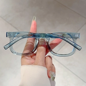 Detail of transparent blue square frame glasses with classic rivets and metal hinges