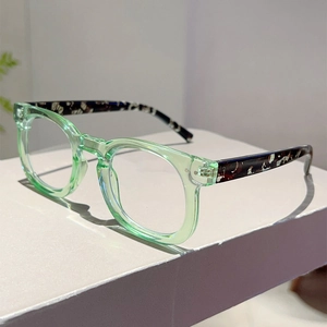 Detail of retro round light green glasses with tortoiseshell temples on a geometric stand