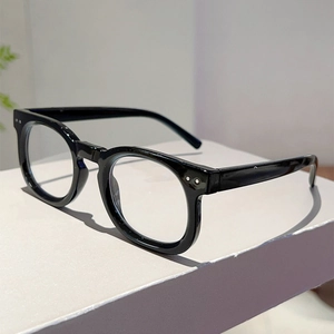 Detail view of classic black round glasses frame with elegant silver rivet accents