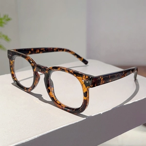 Detailed view of retro tortoiseshell eyewear frame with metal stud accents on the temple