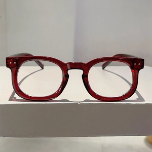 Macro view of retro dark red round glasses with silver stud accents and clear lenses