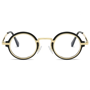 Détail de lunettes rétro rondes avec monture bicolore en métal noir et doré