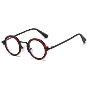 Détail de lunettes rétro rondes montrant la monture bicolore noir et rouge et les branches