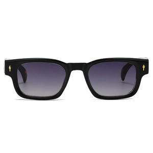Détail de lunettes de soleil carrées noires avec verres dégradés violets et rivets dorés