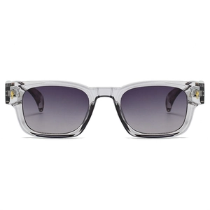 Détail de lunettes de soleil rectangulaires gris transparent avec charnière flèche dorée