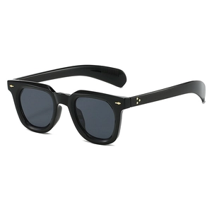 Detail view of black vintage sunglasses featuring gold arrow rivets and star ornaments