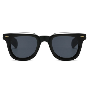 Detail of retro black square sunglasses featuring gold arrow-shaped metal rivets