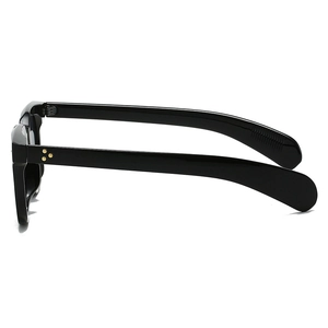Detail view of glossy black sunglasses frame with three golden star rivets on the side