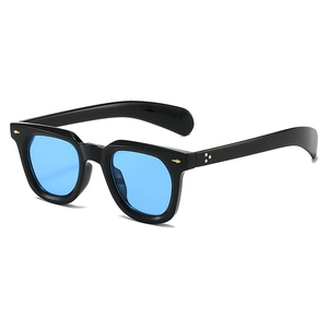 Detail of vintage black frames with blue lenses and golden arrow metal rivets