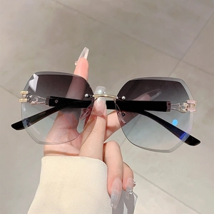 Detail of rimless gradient sunglasses lens with rhinestones and gold metal hardware